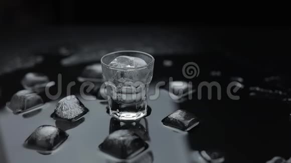 把伏特加倒入玻璃杯里黑色背景倒入酒精饮料视频的预览图