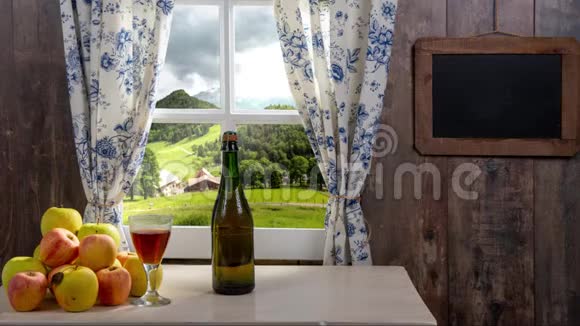 一瓶苹果酒和一杯苹果酒在乡下的房子里视频的预览图