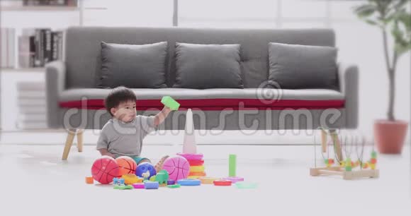 亚洲男孩坐在地板上玩玩具视频的预览图