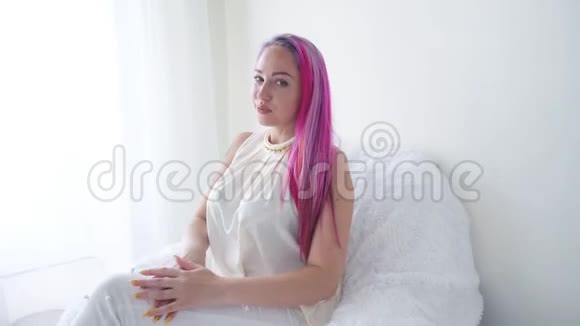 在白色房间里摆着粉色头发的女孩视频的预览图
