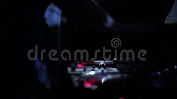 DJ在夜总会的迪斯科舞厅里刮擦唱片和在甲板上混音视频的预览图