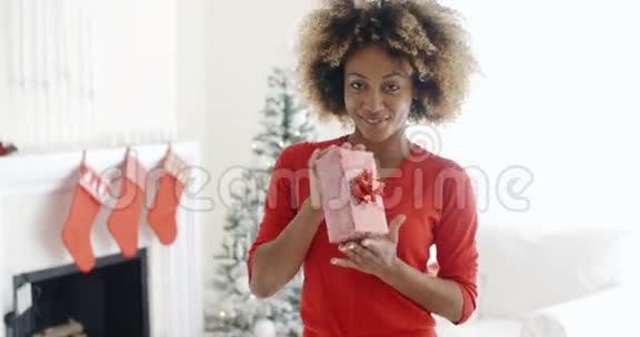 微笑着拿着圣诞礼物的非洲女人视频的预览图