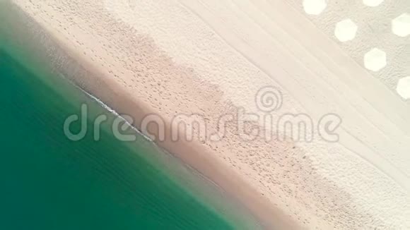 热带岛屿海滩的空中俯视图雨伞沙滩和海浪视频的预览图