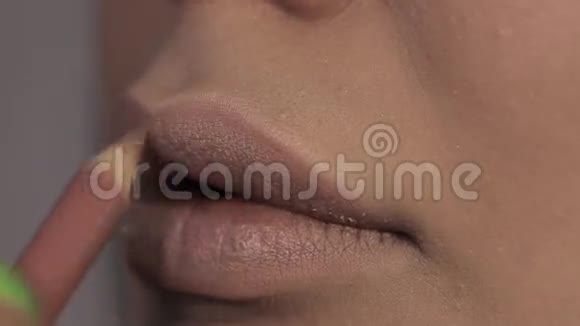 化妆师把嘴唇涂成漂亮女孩丰满的嘴唇视频的预览图
