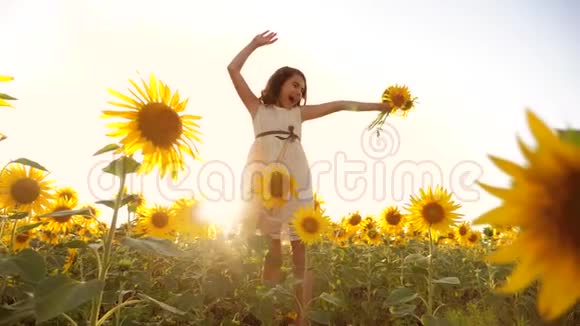 可爱的女孩在黄色的花园向日葵阳光在夏天美丽的生活方式日落小女孩向日葵视频的预览图
