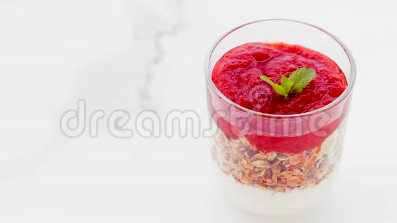 早上提供健康早餐的自制格兰诺拉麦片草莓果酱和薄荷酸奶和梅斯利视频的预览图