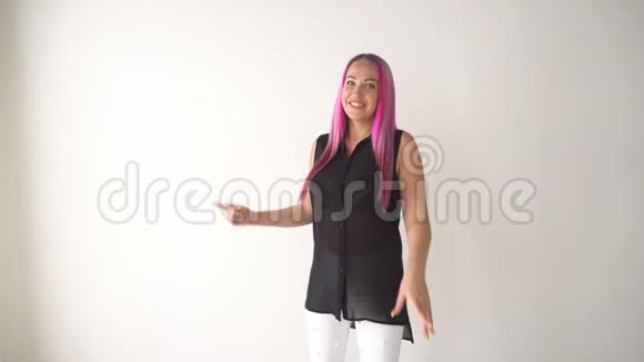 在白色房间里摆着粉色头发的女孩视频的预览图