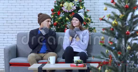 白人夫妇坐在圣诞树中间视频的预览图