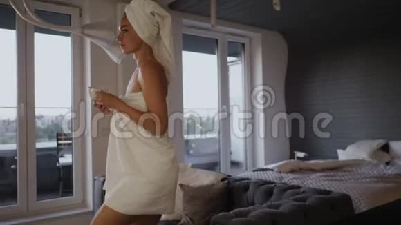 在酒店房间的床上喝咖啡的女人视频的预览图
