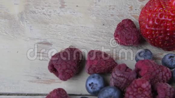 健康混合水果和配料草莓覆盆子蓝莓浅白色木制背景浆果视频的预览图