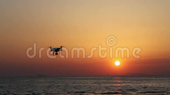 遥控无人机在夕阳下飞翔视频的预览图
