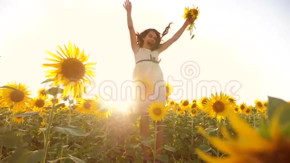 夏日向日葵阳光下的黄色花园里可爱的小女孩生活方式美丽的日落小女孩在向日葵视频的预览图