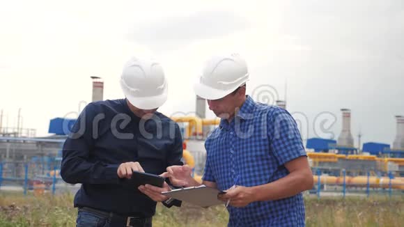 团队合作工业煤气生产站的概念生活方式慢动作视频两名戴头盔的工程师正在学习视频的预览图