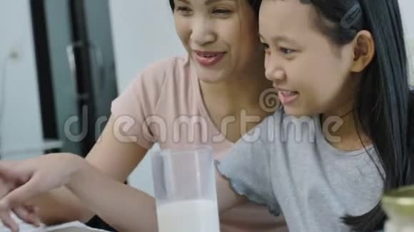 快乐的亚洲家庭母女正在家里使用笔记本电脑视频的预览图