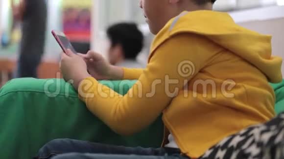 快乐的亚洲孩子在家里使用数字手机视频的预览图