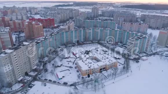 冬季无人驾驶飞机从空中拍摄明斯克市郊区雪日落住宅楼视频的预览图