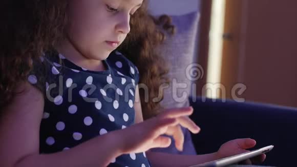 可爱的儿童娱乐与平板小女孩度过闲暇时光玩手机游戏在光明中破碎视频的预览图