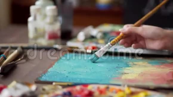 艺术家用调色板的特写画了一幅油画画笔视频的预览图