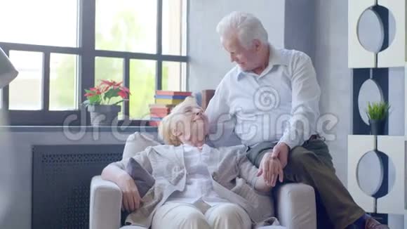 可爱快乐的老年夫妇在现代公寓他们说话微笑视频的预览图