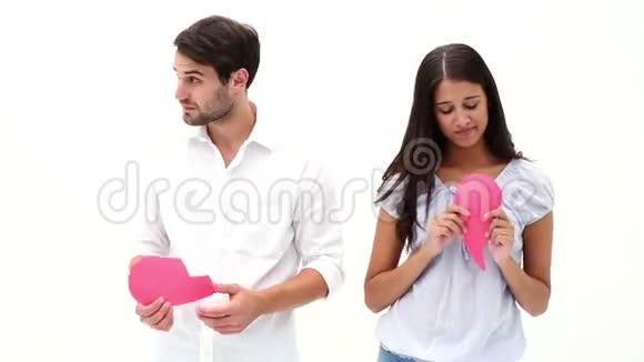 悲伤的年轻夫妇抱着两半破碎的心视频的预览图