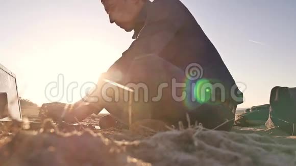 自由职业者个人剪影工作在笔记本电脑自由职业者坐在沙滩日落阳光视频的预览图