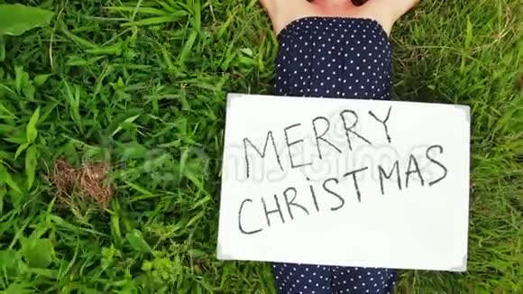 飞行无人机视频年轻女子与红色帽子和白板与手写文字圣诞快乐热带背景视频的预览图