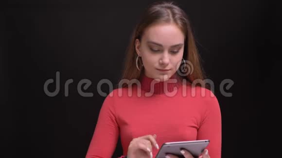 用平板电脑拍摄白种人年轻女性的特写肖像并用绿色屏幕拍摄视频的预览图