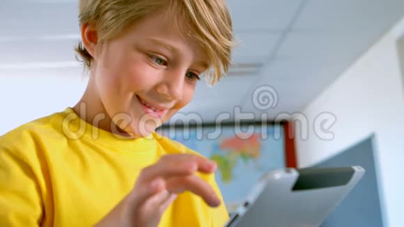 快乐的白人学生在学校的教室里使用数字平板电脑视频的预览图
