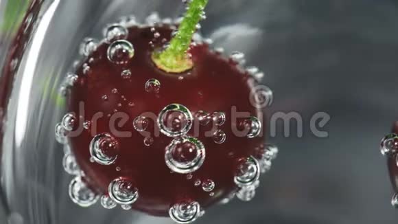 玻璃中的成熟樱桃和苏打水的气泡视频的预览图
