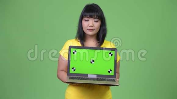 美丽的亚洲女人一边思考一边展示笔记本电脑视频的预览图