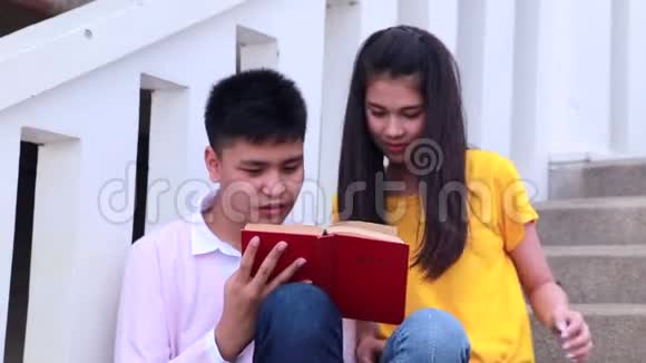 亚洲学生在室外坐楼梯夫妻用书视频的预览图