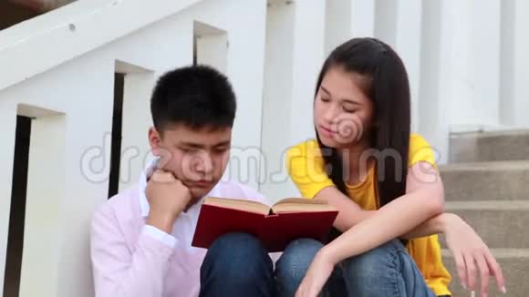 亚洲学生在室外坐楼梯夫妻用书视频的预览图