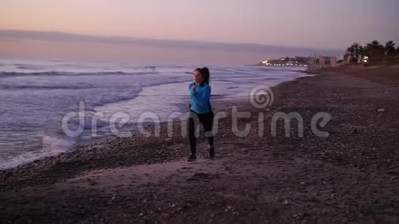 日落时在海滩上奔跑的女人健身理念视频的预览图