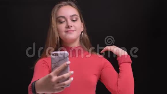 特写照片上年轻的白种人美丽的女性有一个随意的视频电话在电话微笑视频的预览图