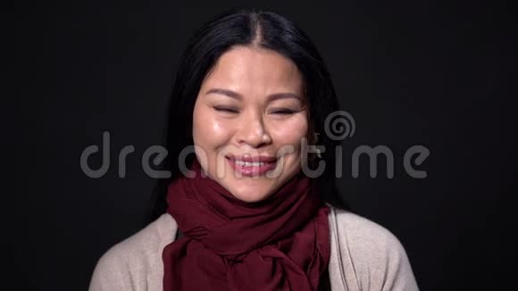 迷人的亚洲女人在黑色背景下微笑视频的预览图