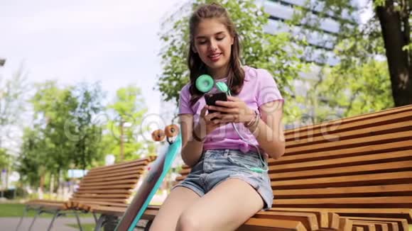 带智能手机和长板的快乐少女视频的预览图