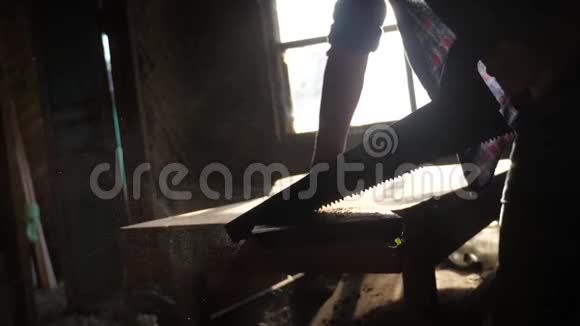 匠心手工与工艺概念慢动作视频木匠在生活车间锯树锯阳光视频的预览图