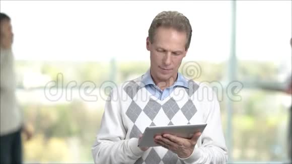 成熟的男人在电脑平板电脑上工作视频的预览图