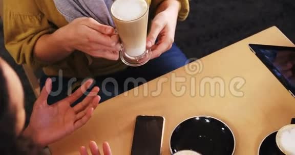 朋友在喝咖啡时使用手机和数码平板电脑视频的预览图