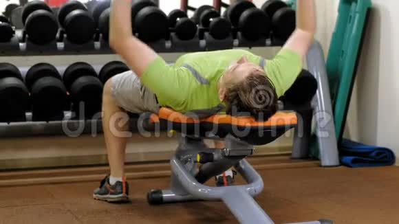 在健身室用哑铃做长凳按压的人视频的预览图