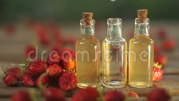 美丽的玻璃罐桌上放着野草莓的精华视频的预览图