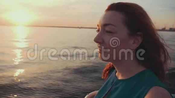 红发快乐女孩穿着运动船美丽的日落娱乐视频的预览图