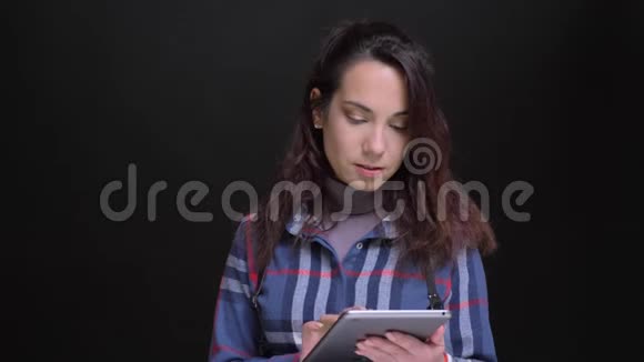 用平板电脑特写年轻美丽的白种人女性的肖像并用绿色屏幕拍摄视频的预览图