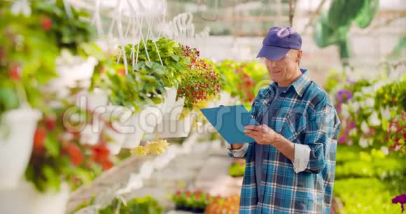 自信的男花匠检查盆栽植物视频的预览图