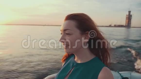 在摩托艇上穿裙子的红头发女孩美丽的夏日日落娱乐视频的预览图