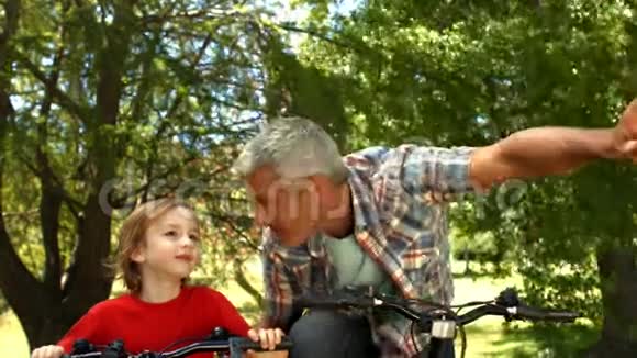 父亲和儿子在公园骑自行车视频的预览图