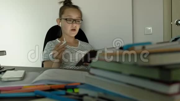 少女使用带有耳机的平板电脑晚上时间视频的预览图