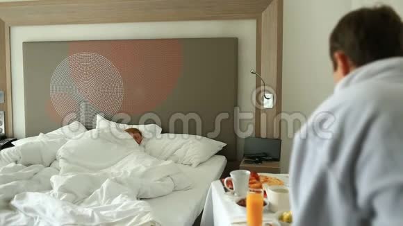 年轻夫妇在公寓的床上吃早餐视频的预览图