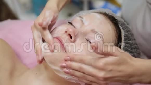 水疗女人面部按摩美容水疗沙龙面部按摩在美容水疗中心享受放松面部按摩的女性视频的预览图