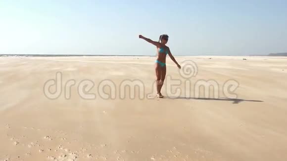 快乐的年轻女人在海滩上跳跃视频的预览图